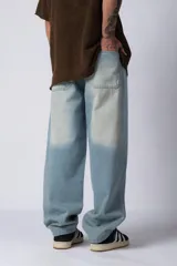 Jean de corte baggy con diseño amplio y holgado, confeccionado en denim de lavado claro con efecto desgastado en las piernas.