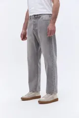Pantalón de jean con corte baggy, tiro medio y diseño amplio en piernas y cadera. Cuenta con pasacintos y cierre frontal con botón.