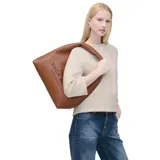 Cartera tipo hobo Marc Jacobs modelo The Sack, confeccionada en cuero premium color marrón con textura granulada. Presenta el logo de la marca estampado en el frente y una correa integrada para llevar al hombro.