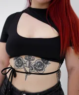 Top negro con manga corta, escote asimétrico con abertura en el pecho y lazos finos para atar en la cintura.