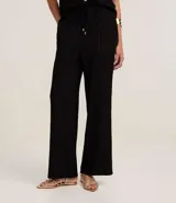 Pantalón femenino de corte recto y fluido, cintura alta con elástico y lazo ajustable. Tejido de chiffon texturizado.