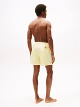 Short de baño de corte medio, confeccionado en poliéster reciclado con estampado botánico degradado en tonos amarillos y blancos. Cuenta con cintura elástica con cordón ajustable, forro de malla interior, dos bolsillos laterales y logo de la marca en el lateral.