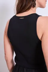 Blusa sin mangas de punto, con cuello redondo y ajuste al cuerpo.