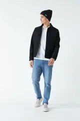 Campera de gamuza color verde oliva, con cuello medio, bolsillos tipo cartera y cierre frontal con botones.