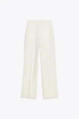 Pantalón de tiro alto color crudo, de pernera recta con detalle de bandas laterales desflecadas.