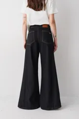 Jean de corte wide leg con tiro alto, confeccionado en denim azul. Presenta un diseño de pierna muy amplia, costuras laterales marcadas y ruedo deshilachado.