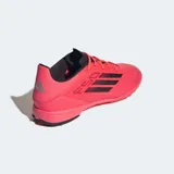 Championes Adidas F50 League para césped sintético, color rosa vibrante con las tres franjas negras. Presentan un diseño ligero con parte superior Fiberskin, estampado Sprintgrid en el antepié y lengüeta elástica.