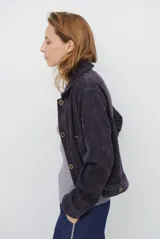 Chaqueta de pana color azul oscuro, con cuello camisero, cierre frontal con botones y bolsillos laterales. Diseño de corte recto y manga larga.