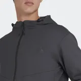 Campera deportiva con capucha y cierre frontal, color gris oscuro, con logo de Le Coq Sportif en el pecho y bolsillos laterales con cierre. Presenta paneles con costuras diagonales en el frente.