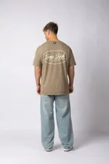 Remera de algodón con efecto lavado, color marrón, de corte holgado y manga corta. Presenta pequeños estampados gráficos en el pecho.