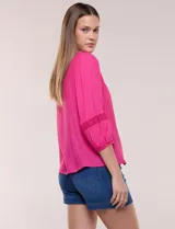 Blusa blanca de bambula con escote en V, pechera de encaje y mangas 3/4 abullonadas con detalles de puntilla.