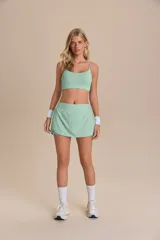 Pollera deportiva color verde menta, de corte corto con laterales redondeados y shorts internos. Confeccionada en tejido tecnológico de secado rápido.