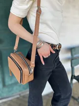 Bandolera color camel de cuero con forro de tela, bolsillo interior y exterior.