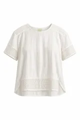 Blusa Maria blanca de manga corta, con detalles de encaje en los hombros, mangas y en el panel inferior delantero. Presenta cuello redondo y dobladillo asimétrico más largo en la parte trasera.