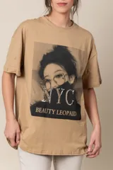 Remera blanca de algodón con estampa frontal de una mujer con anteojos y la inscripción "NYC Beauty Leopaid" con apliques de tachas.