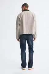 Pantalón jean de cinco bolsillos en denim de algodón con lavado azul oscuro, cintura clásica y corte de pierna recta.