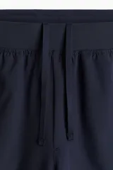 Short deportivo de tejido funcional con tecnología DryMove para absorción de sudor. Presenta cintura elástica con cordón de ajuste oculto, bolsillos laterales al bies y aberturas laterales en el bajo. Diseño con stretch en cuatro direcciones y detalles reflectantes.