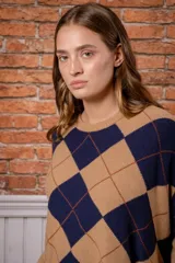 Sweater de punto con diseño de rombos en colores beige y azul marino, cuello redondo y mangas largas.