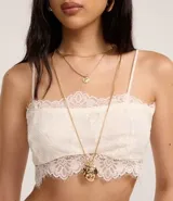 Blusa cropped de encaje color blanco, con escote recto, breteles finos y forro.