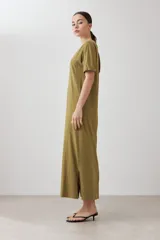 Vestido largo verde oliva con cuello en V, mangas cortas y costuras verticales.
