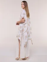 Kimono de gasa verde con estampado de hojas blancas y detalles de lurex. Presenta mangas cortas holgadas, diseño abierto al frente y terminación en punta con borlas en el ruedo.