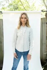 Camisa de lino con estampado floral en tonos pasteles, cuello camisero, manga larga y detalle de jabot con encaje color natural en la parte delantera.