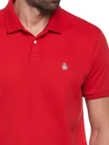 Polo roja de piqué de algodón orgánico, corte recto, cuello con solapa y logo bordado en el pecho.
