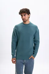 Buzo de punto con cuello redondo y diseño acanalado, de manga larga y corte holgado.