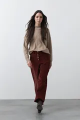 Pantalón de pana de corte wide leg, color marrón oscuro, con calce relajado y detalle de bordado en el borde de los bolsillos delanteros.