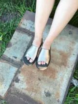 Sandalias chatas de cuero color peltre, fabricadas en Uruguay.