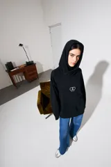 Canguro negro oversize de algodón con capucha y bolsillo delantero tipo canguro. Logo bordado en el pecho.