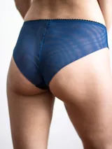Bombacha semitransparente de color azul, confeccionada en tejido elástico con diseño sin costuras y terminación con borde ondulado negro en la cintura.