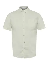 Camisa de manga corta color verde claro, confeccionada en lino orgánico. Presenta cuello camisero, cierre frontal de botones, bolsillo aplicado en el pecho con detalle bordado y dobladillo redondeado.