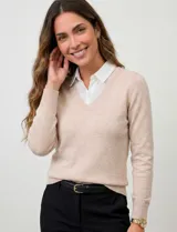 Buzo combinado con torso de tejido de punto fino en color negro y detalles de cuello y ruedo en gasa blanca que simulan una camisa debajo. Presenta escote en V y mangas largas.