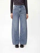 Jean de corte amplio y tiro medio, confeccionado en denim celeste con costuras decorativas laterales que crean un diseño geométrico.