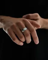 Anillo de plata con textura grabada que simula el patrón de rayas de una cebra, con el logo de la marca Twojeys grabado en el interior.