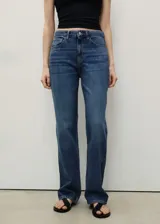 Pantalón de jean tiro medio, corte recto y clásico diseño de cinco bolsillos, confeccionado en algodón.