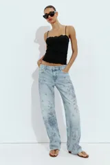 Jeans Z1975 de tiro medio y pernera recta con diseño de cinco bolsillos, cierre frontal con cremallera y botón, y delicado estampado floral en tonos azules.