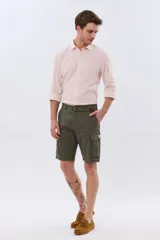 Bermuda cargo color azul marino, de gabardina con bolsillos laterales con solapa en las piernas y presillas para cinturón. Incluye cinturón de lona trenzada oscura con detalles en cuero sintético y hebilla metálica.