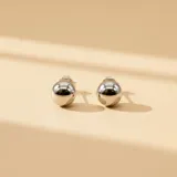 Aros tipo bolita de plata 925 con acabado pulido y cierre de presión.