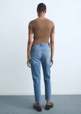 Jeans estilo mom fit de tiro alto y diseño crop, confeccionados en tejido de algodón vaquero en color azul medio. Cuenta con cierre delantero de cremallera y botón, trabillas para cinturón y diseño clásico de cinco bolsillos.