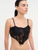 Corset negro de encaje con copas preformadas y tirantes finos regulables.