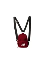 Mini mochila New Balance color bordó con correas ajustables negras y bolsillo frontal con cierre, destacando el logo de la marca en blanco.