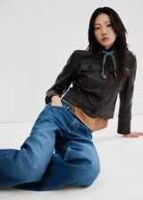 Jeans de corte recto y tiro medio con diseño de cinco bolsillos, trabillas para cinturón y cierre frontal con botón y cremallera.