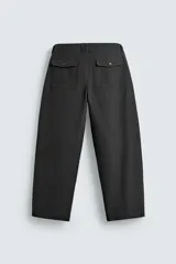 Pantalón de corte balloon fit, color negro, con bolsillos laterales de vivo y bolsillos traseros con solapa. Presenta cierre frontal con cremallera y botón.