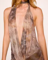 Vestido largo de microtul con estampado abstracto en tonos marrones y beige. Diseño con escote halter y espalda descubierta.