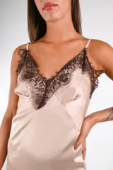 Vestido midi de satén negro, corte lencero, con escote en V adornado con encaje negro. El ruedo es asimétrico y también presenta un borde de encaje.