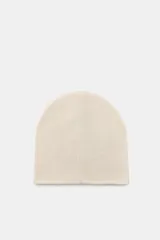 Gorro tipo beanie de punto color crema, con detalle de múltiples bordados coloridos que incluyen figuras como un perro salchicha, flores, lazos y objetos decorativos.