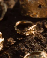 Anillo abierto de diseño orgánico con textura irregular y acabado brillante, realizado artesanalmente en metal.