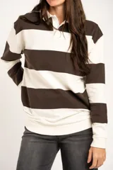 Sweater tipo polo de algodón con diseño de rayas horizontales anchas en color marrón y crema. Presenta cuello camisero, cierre frontal con botones ocultos y mangas largas con puños ajustados.